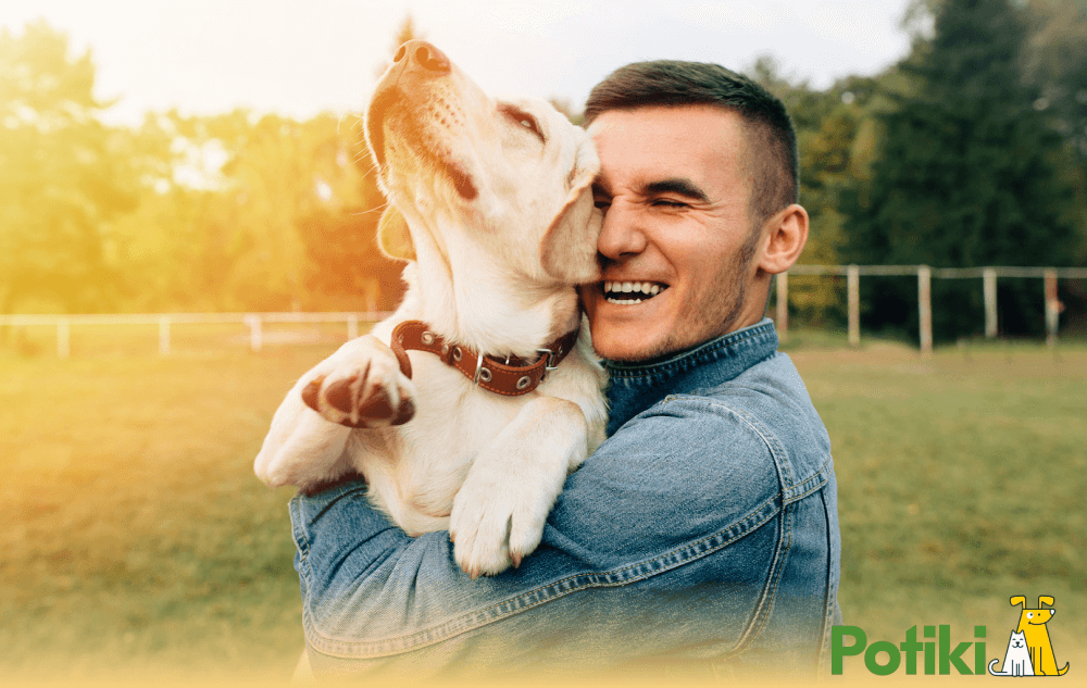 A smiling man hug a dog