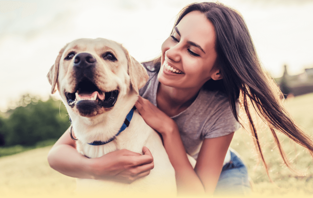 Best Pet Insurance - happy women hugging Labrador dog